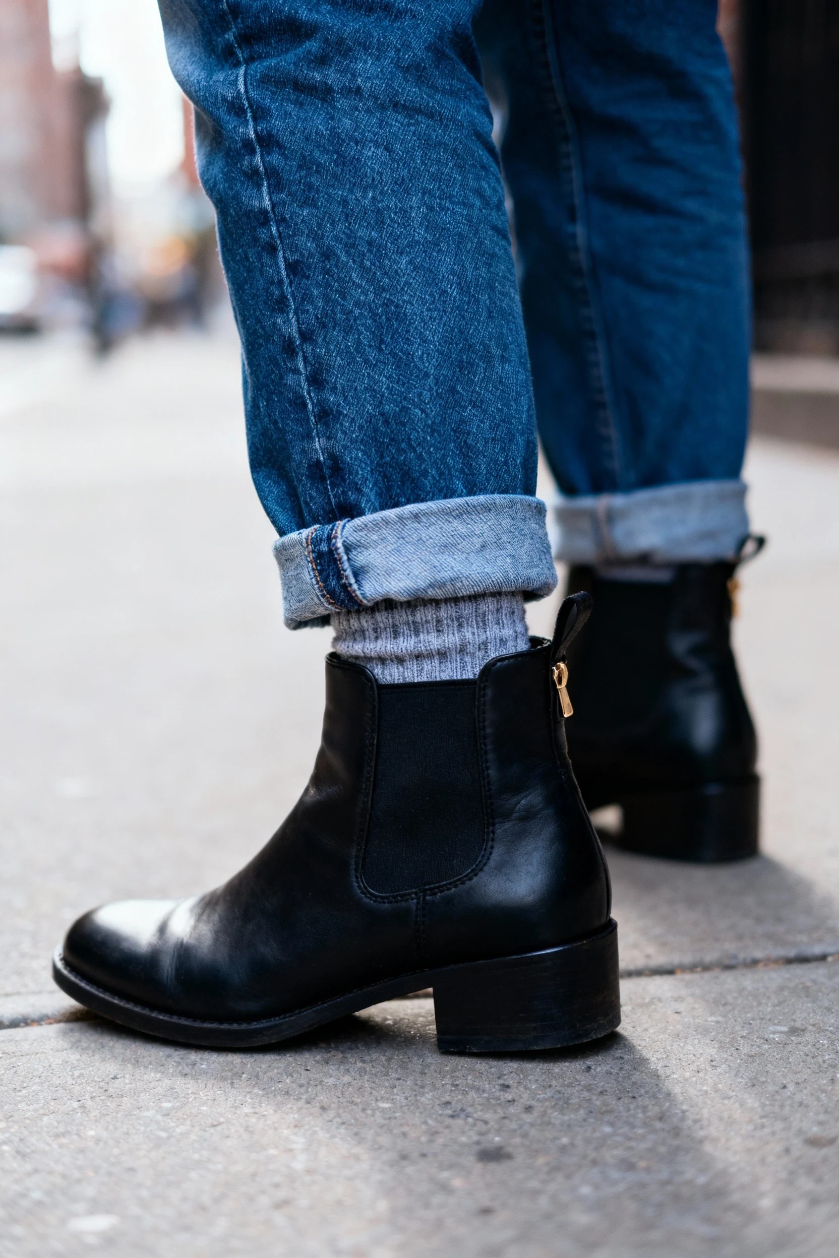 closeup cuffed jeans, sock peeking above black ankle boots
