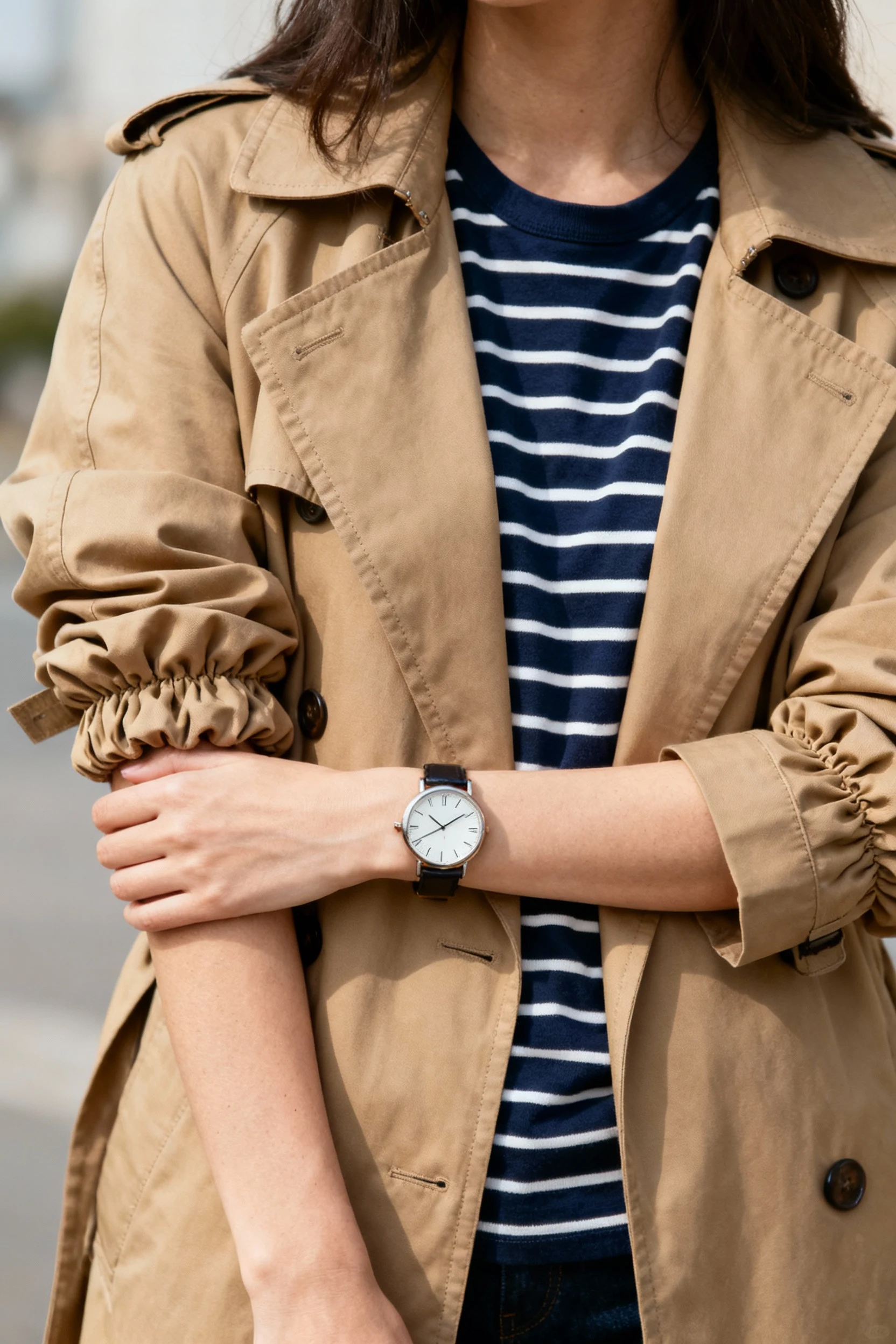 closeup female tan trench sleeves scrunched, navy striped tee, watch
