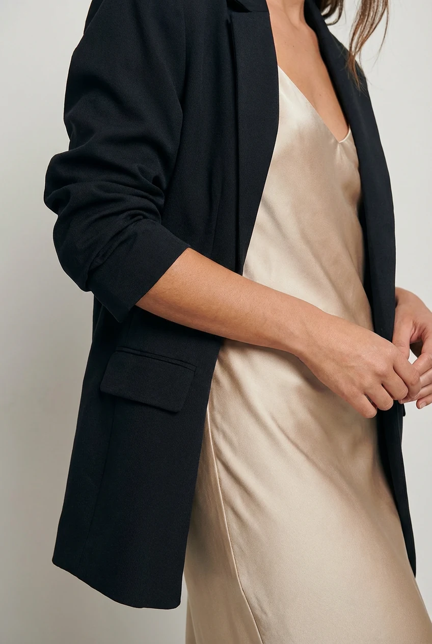 closeup female silk slip dress, blazer sleeves pushed