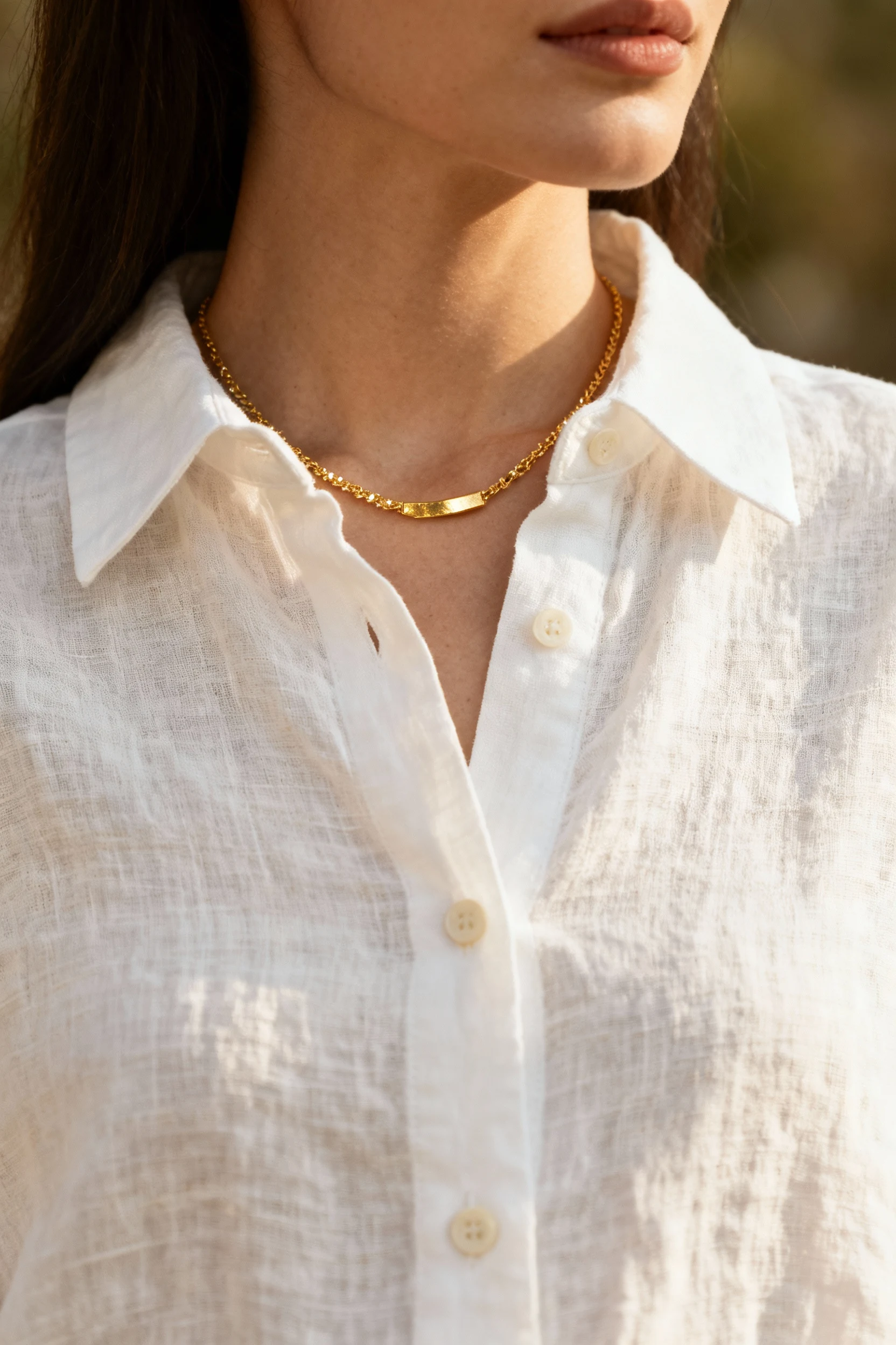 closeup female white linen button-down collar, gold necklace