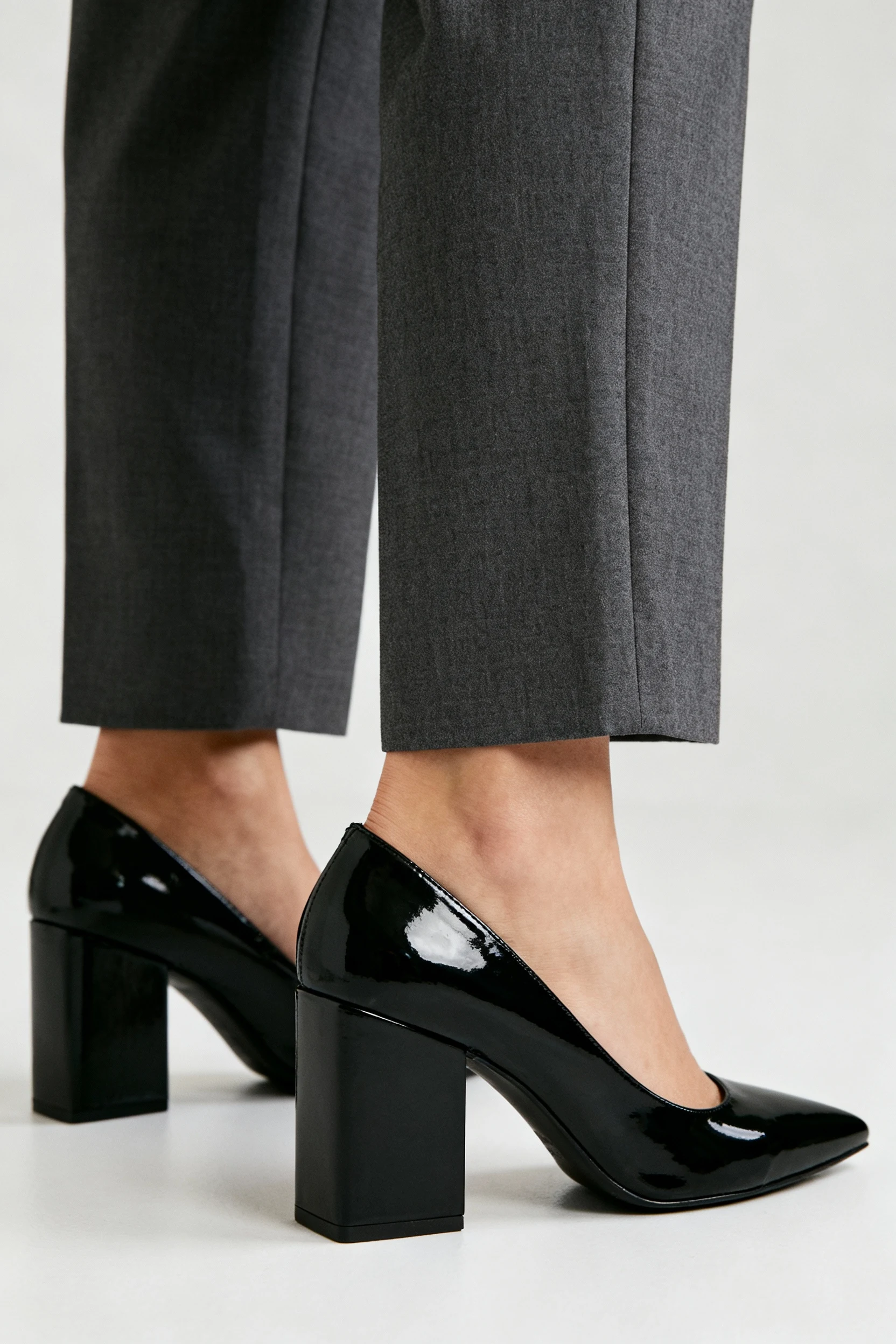 closeup of cropped charcoal trousers above black block heels
