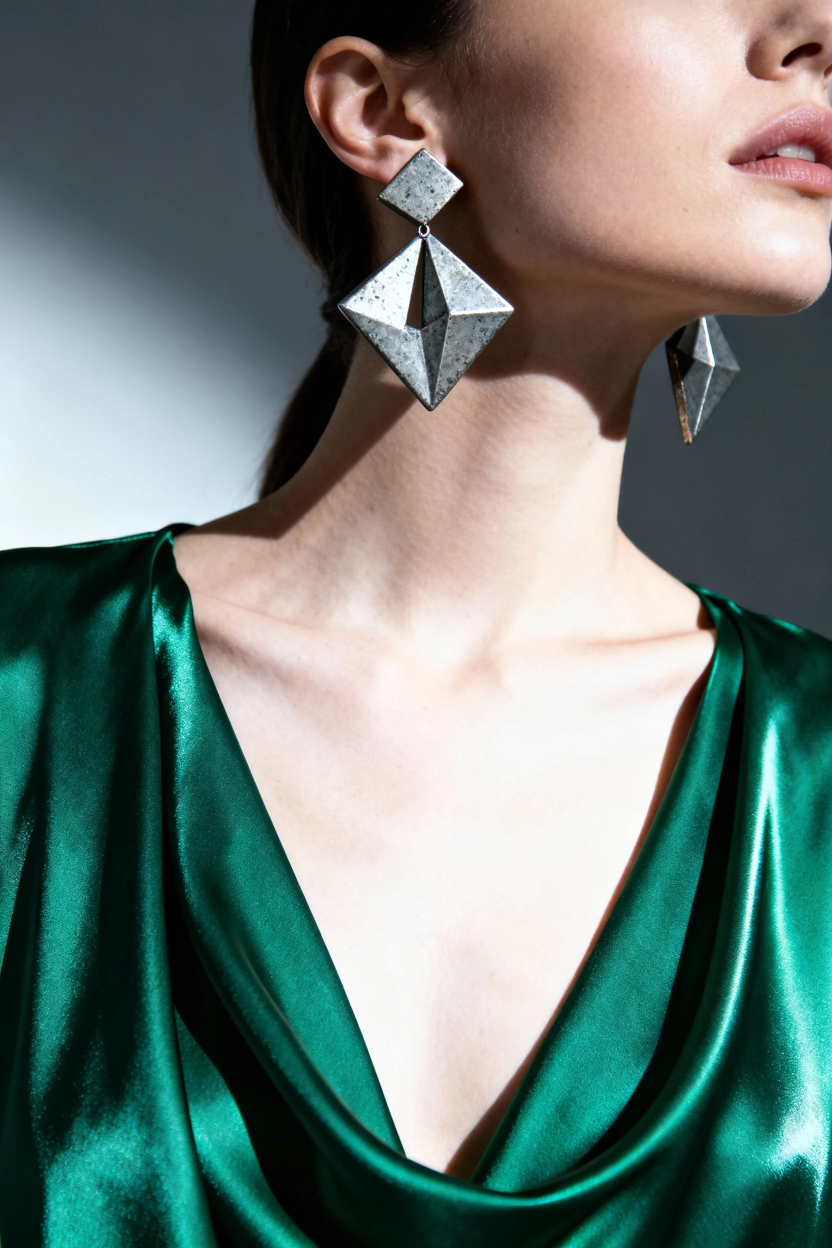 closeup female neck, sculptural earrings, emerald satin kaftan