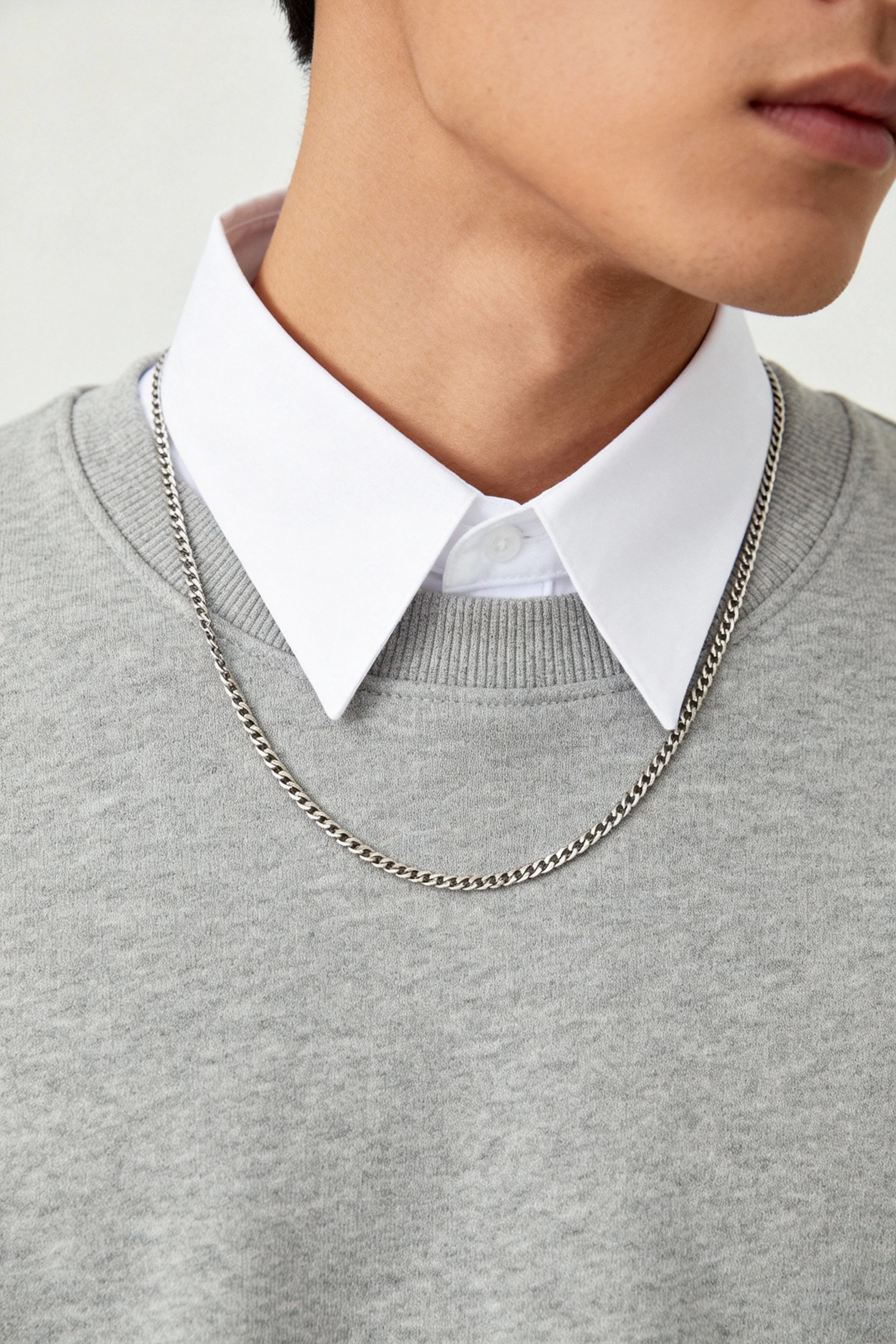 closeup white collar under gray crewneck sweatshirt, thin chain