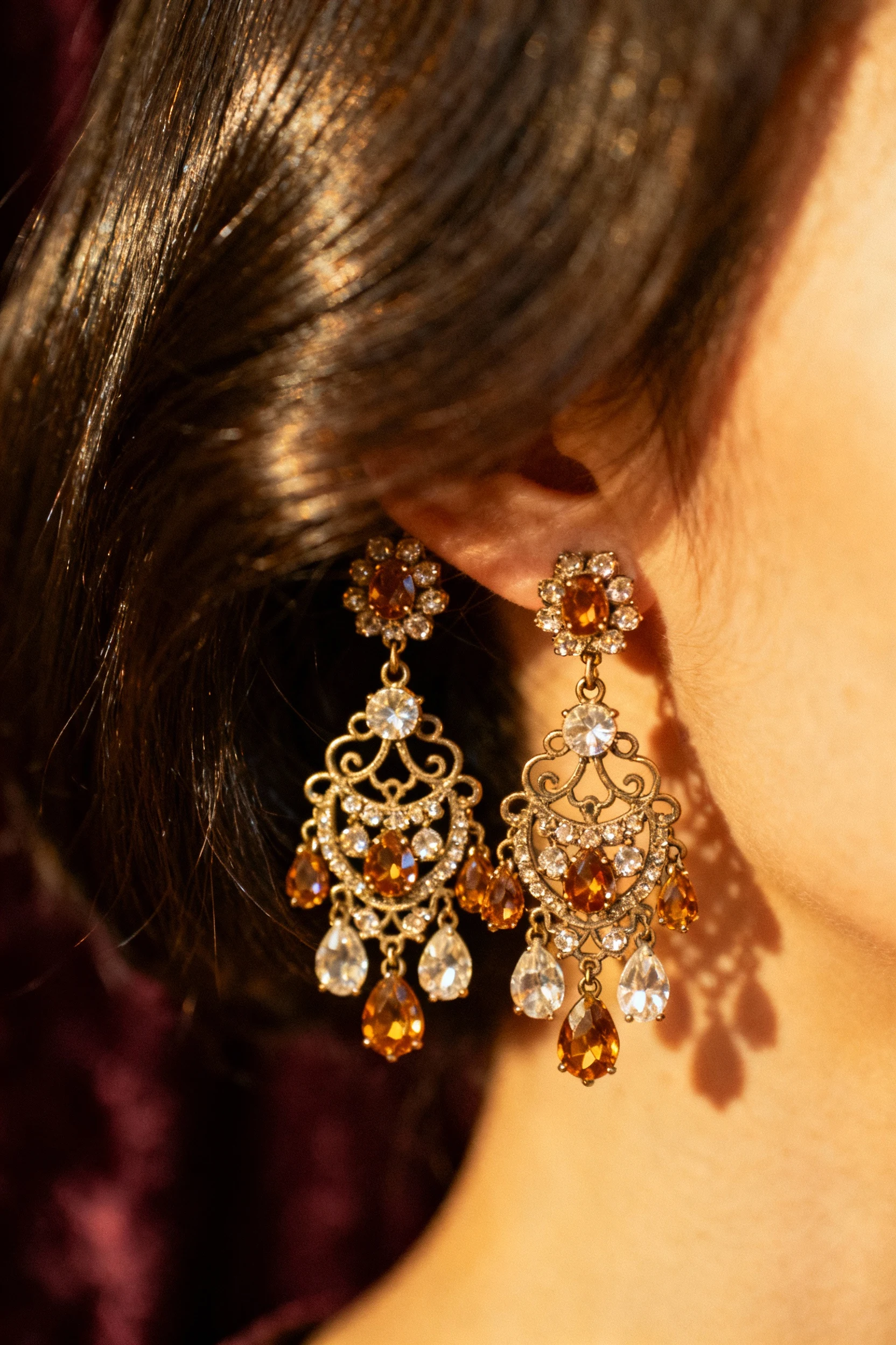 closeup female vintage rhinestone chandelier earrings, sleek hair