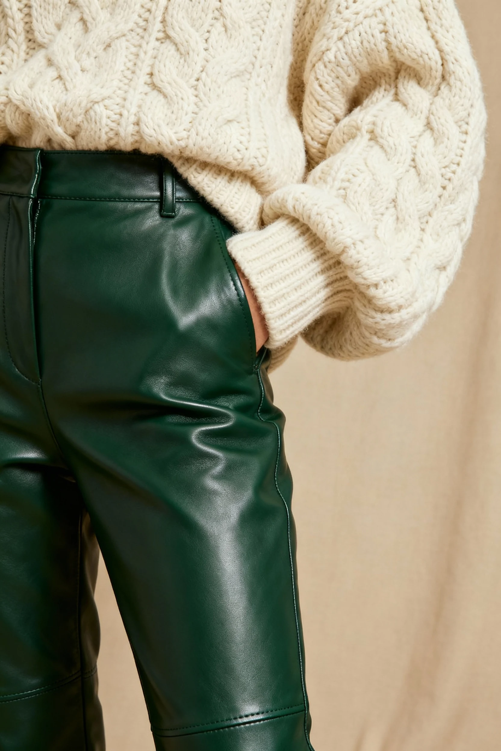 closeup of deep green leather pants paired with soft chunky knit sweater