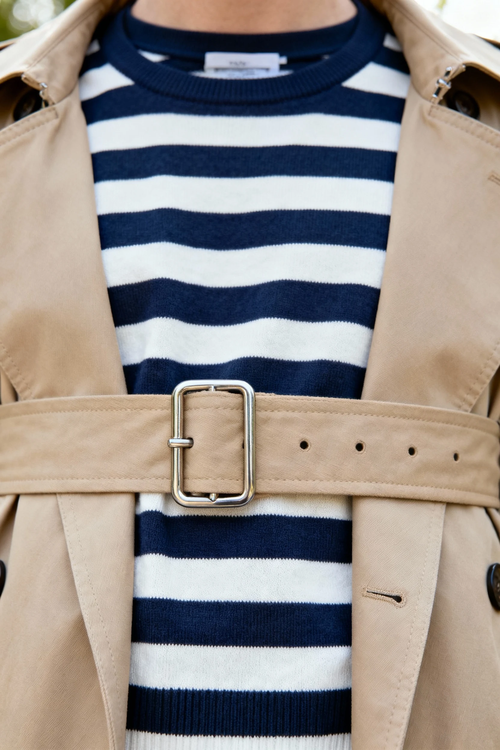 closeup of beige trench belt over navy striped tee