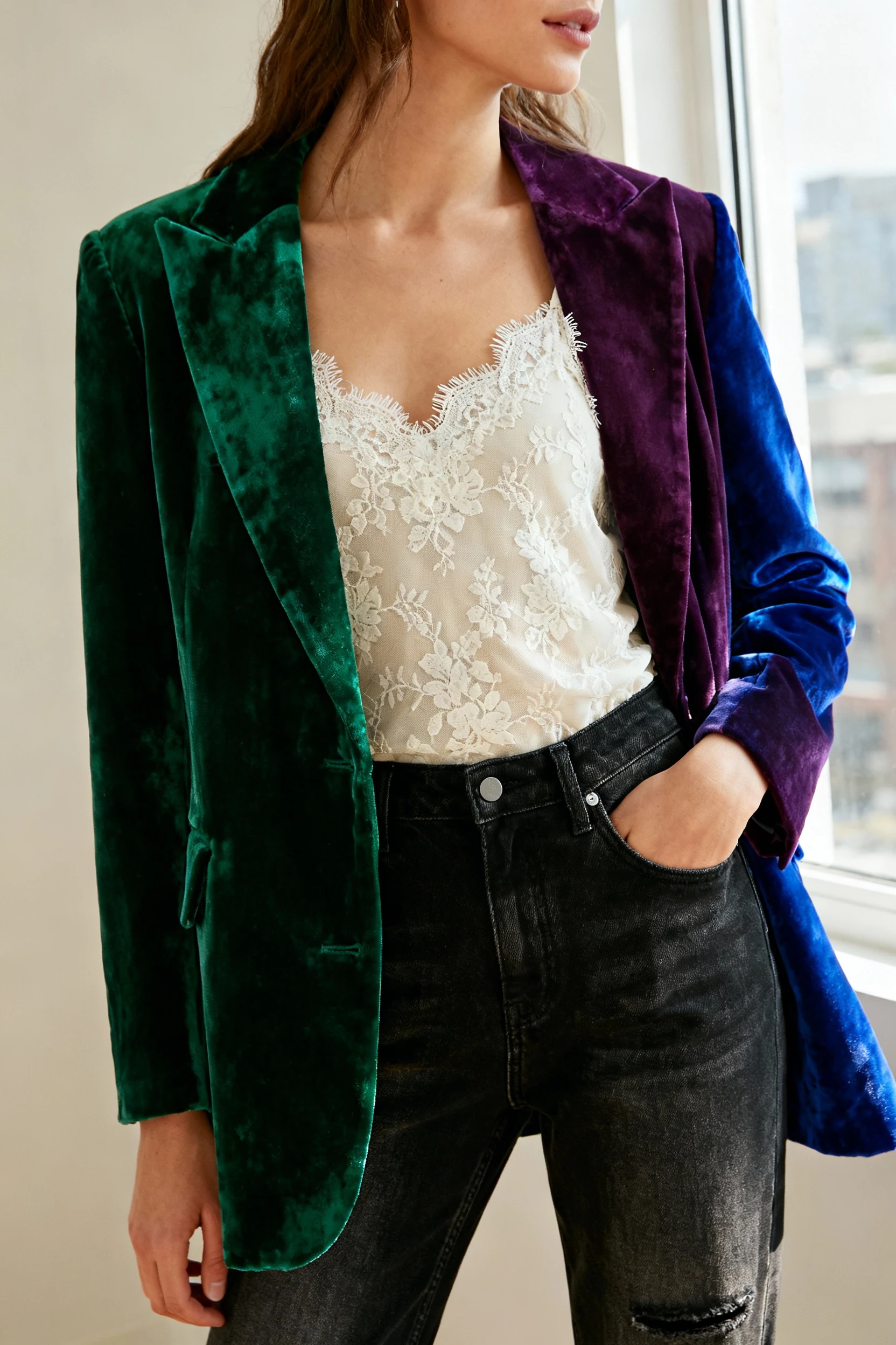 female wearing jewel-toned velvet blazer over lace camisole with straight-leg jeans