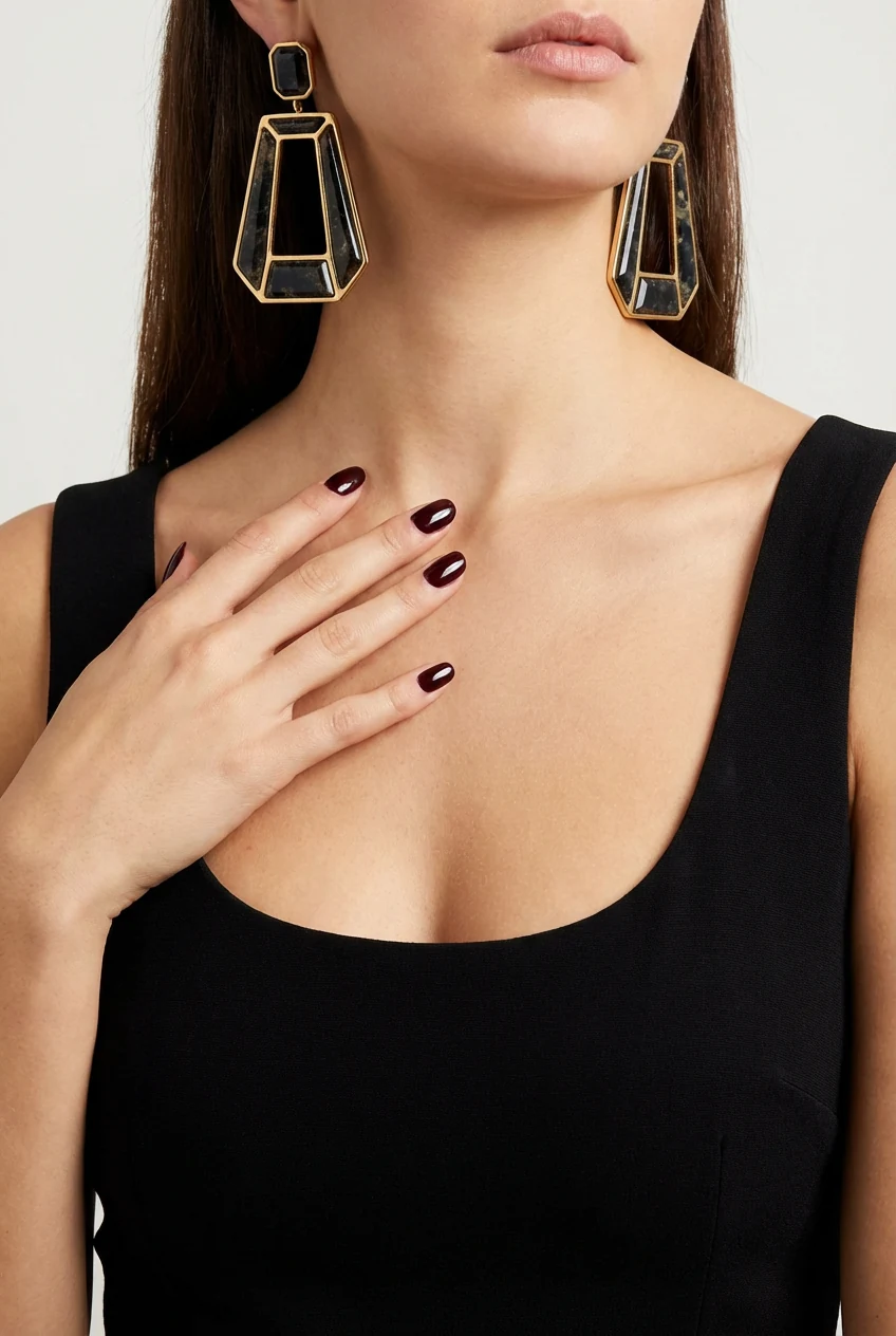 closeup LBD neckline, bold statement earrings, glossy nails