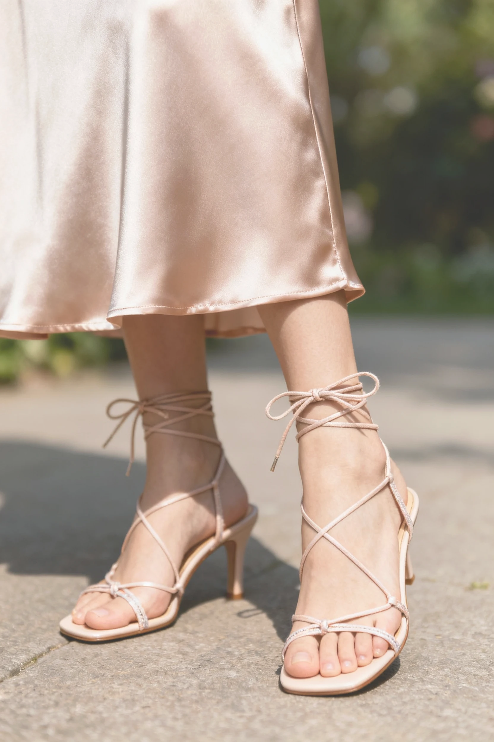 closeup satin midi skirt hem, thin lace-up sandals