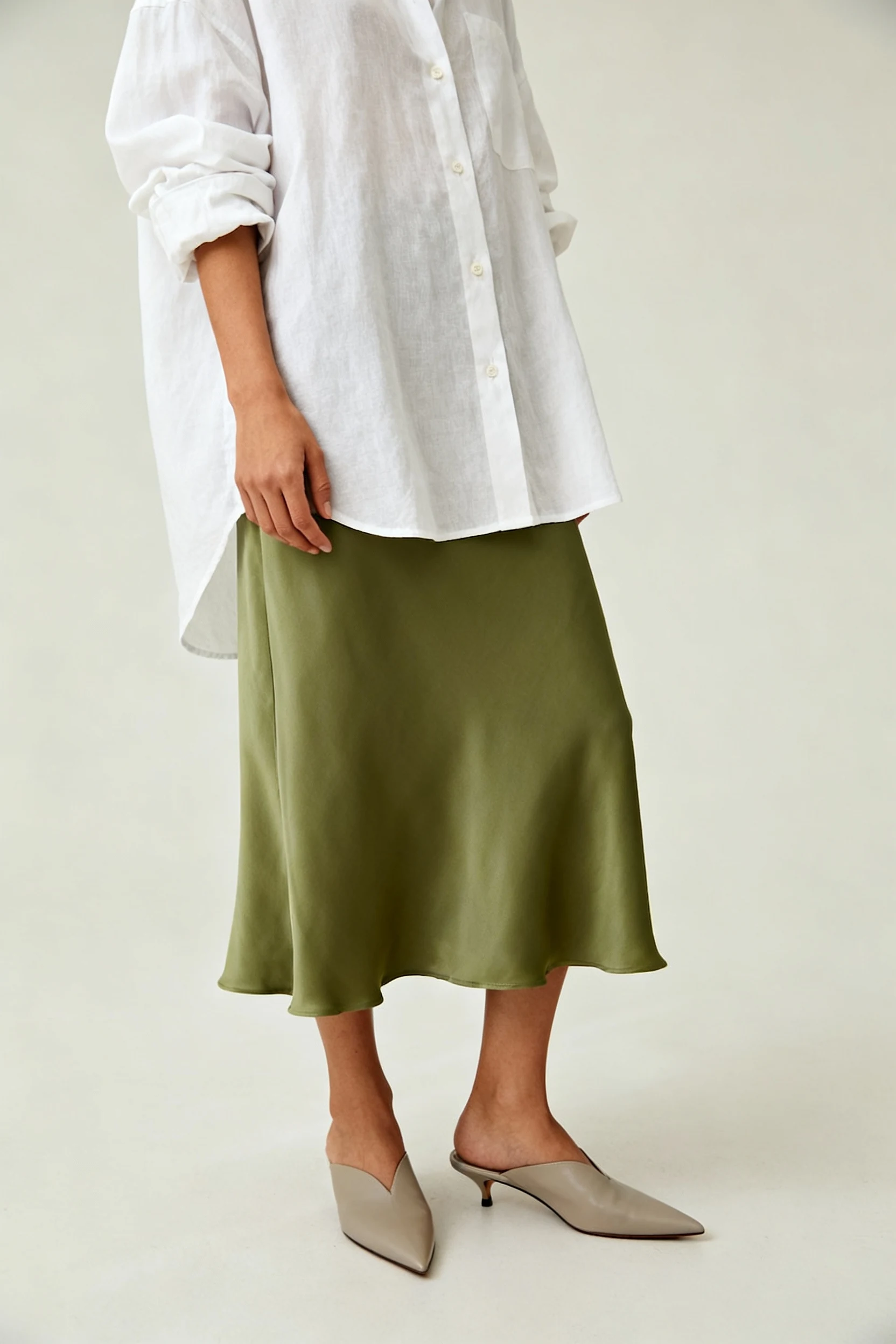closeup rolled sleeves oversized white button-down, pointed mules, sage skirt