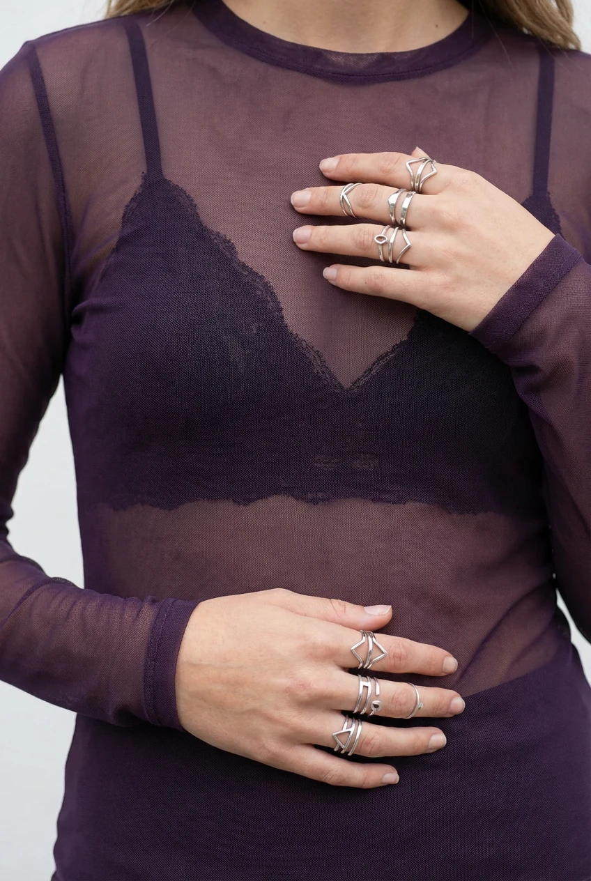closeup sheer purple mesh top, black bralette, silver rings