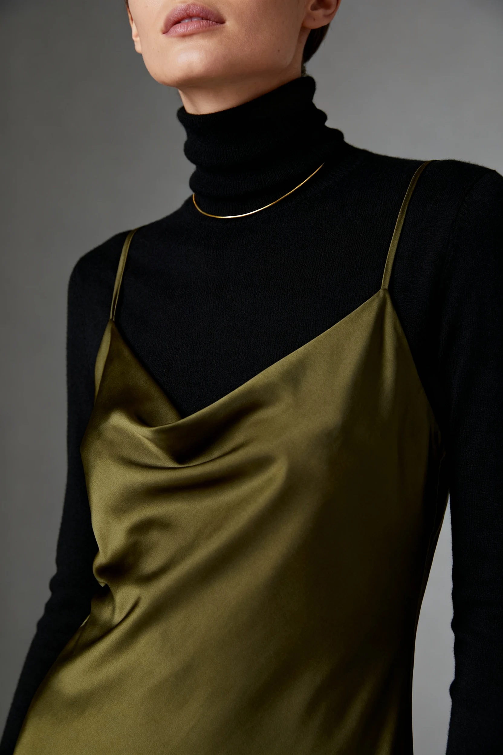 closeup of female wearing black turtleneck under olive satin slip