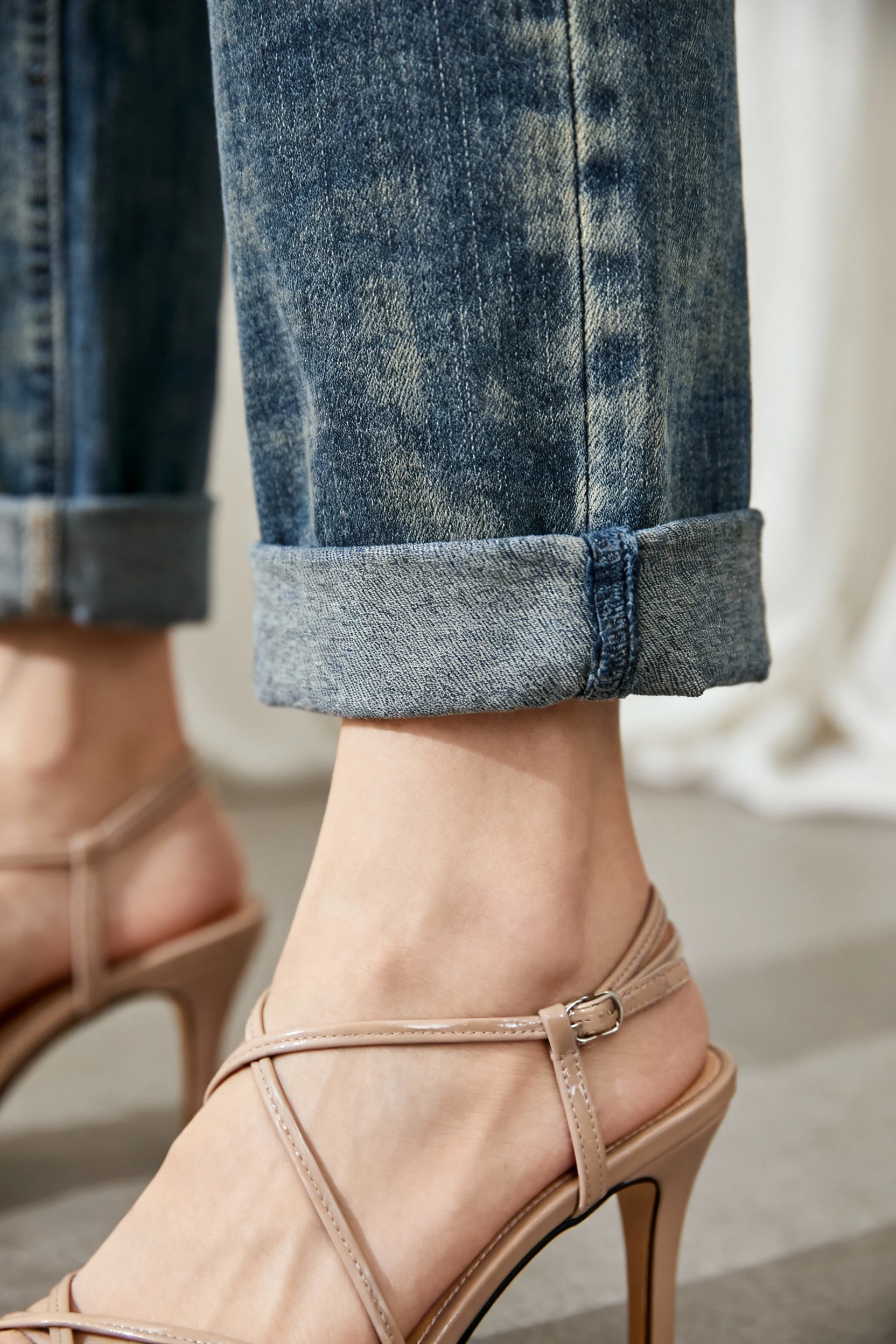 closeup of cuffed straight-leg jeans and strappy heels