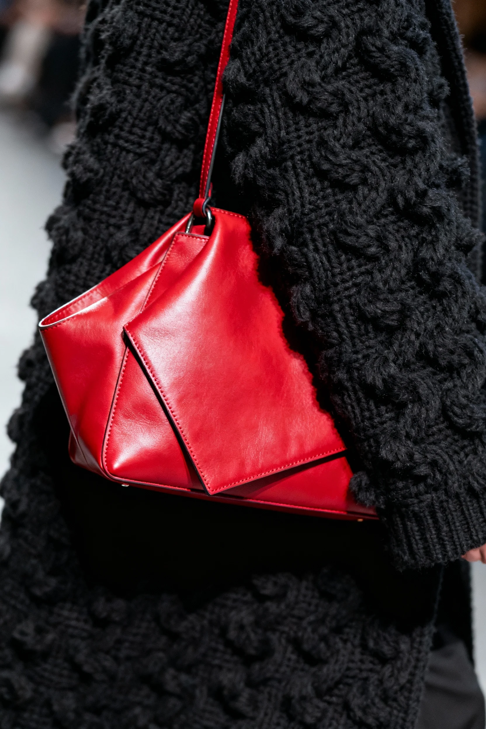 closeup bold statement coat texture, black knit, red bag
