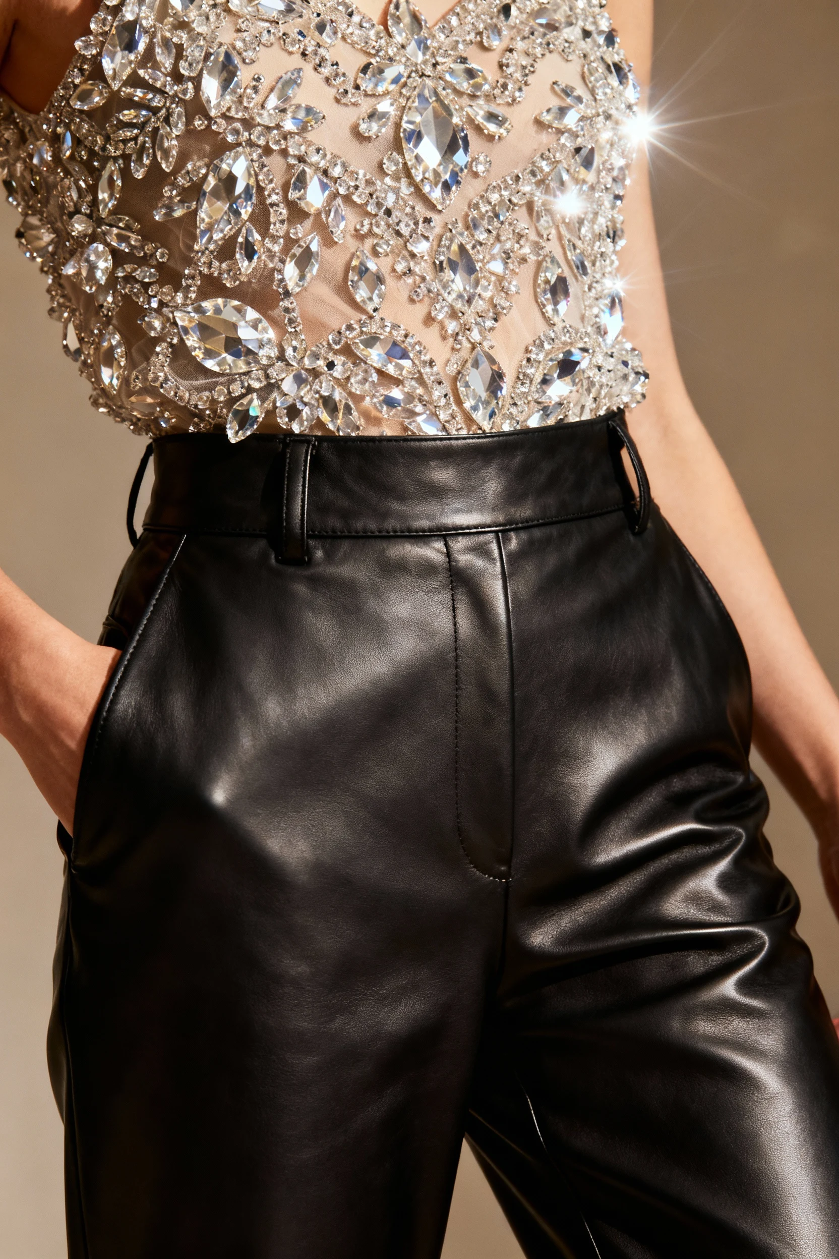 straight-leg leather pants, female waist, crystal-embellished top closeup