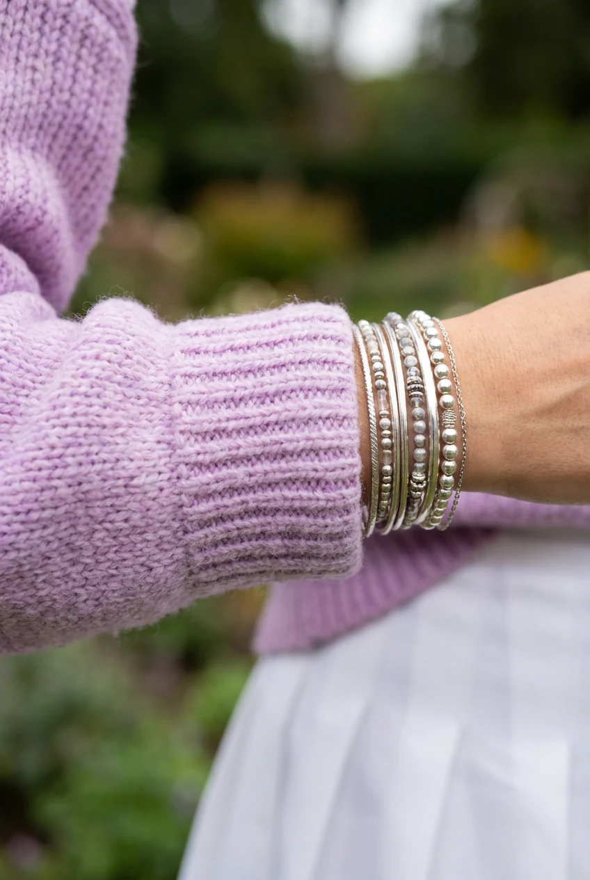 closeup lilac sweater sleeves, bracelet stack, white tennis pleats